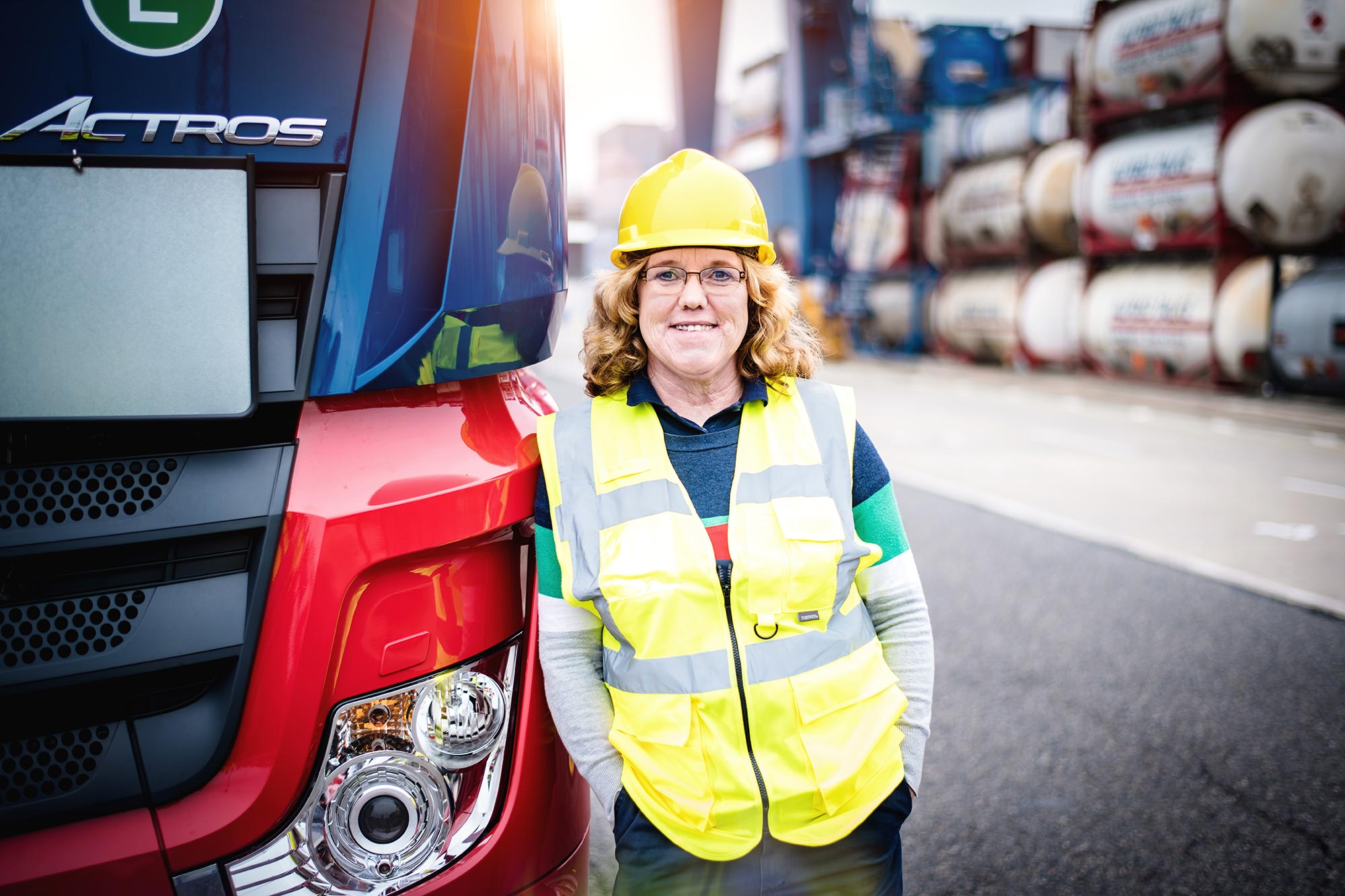 Talke Logistics Mitarbeiter Motive LKW Fahrerin vor ihrem Truck freundlich zuversichtlich professionell Truckerin
